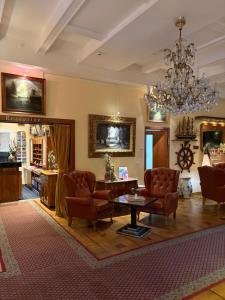 a living room with chairs and a table and a chandelier at Hotel Stolteraa in Warnemünde