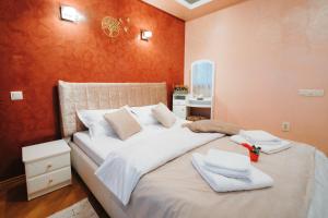 a bedroom with a bed with white towels on it at Downtown Cozy Retreat - parcare inclusa in Vatra Dornei