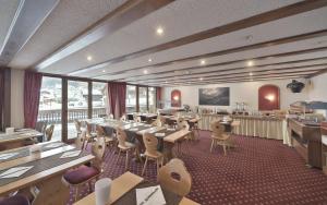 a restaurant with tables and chairs in a room at Hôtel Le Chamois in Les Diablerets