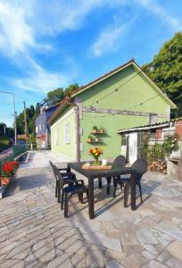 a patio with a table and chairs and a green building at Casa rural Solpor in Vigo