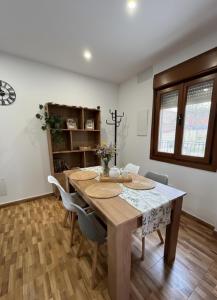a dining room with a wooden table and chairs at Casa rural Solpor in Vigo