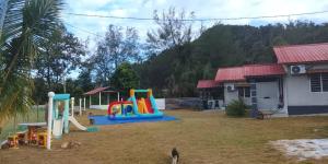 a playground in a yard next to a house at Mersing Chalet Teluk Sisek in Kampong Sisek