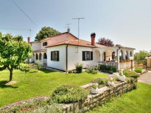 a house with a garden in front of it at Room PARADINOVIĆ in Zambratija
