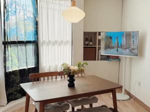 a dining room table with a vase of flowers on it at Ansik in Busan