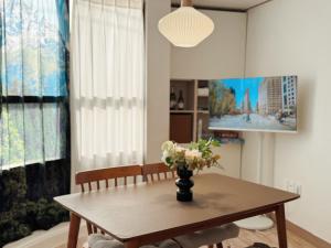 a dining room table with a vase of flowers on it at Ansik in Busan