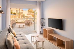 a living room with a couch and a flat screen tv at Dormio Resort Costa Blanca Beach & Spa in El Campello