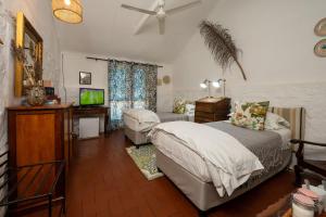 a bedroom with a bed and a flat screen tv at Kuilfontein Stable Cottages in Colesberg