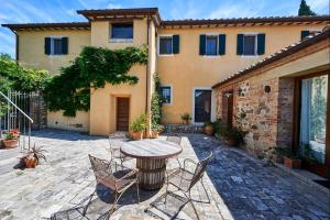 a patio with a table and chairs in front of a building at Villa Beltramonto by MMega in Castiglioncello del Trinoro