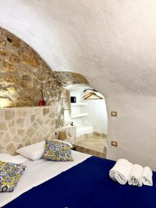 a bedroom with a bed and a stone wall at Mare' in Vieste