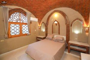 a bedroom with a bed and a window at Nefertari Palace apartments in Al Aqālitah