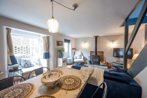a living room with a blue couch and a table at No33 HILLVIEW LODGE BOUTIQUE COTTAGE in Brancaster