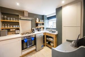 a kitchen with a sink and a stove top oven at No33 HILLVIEW LODGE BOUTIQUE COTTAGE in Brancaster