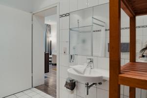 a white bathroom with a sink and a mirror at Hotel & Gasthaus Backmulde in Heidelberg +122 photos
