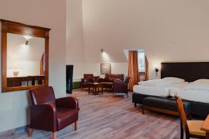a hotel room with a bed and a couch and chairs at Hotel & Gasthaus Backmulde in Heidelberg