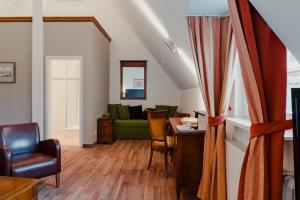 a living room with a green couch and a table at Hotel & Gasthaus Backmulde in Heidelberg