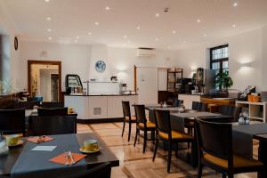 a restaurant with tables and chairs and a kitchen at Hotel & Gasthaus Backmulde in Heidelberg