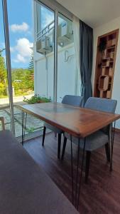 a wooden table and chairs in a room with a window at Sling & Stone Mountain Suites - Heritage House in Kampong Kundassan