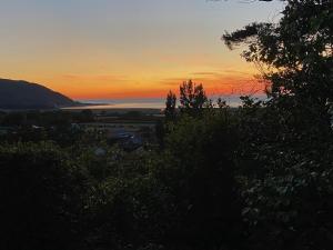 a sunset from the top of a hill with trees at Bay View Porlock Bed & Breakfast in Porlock