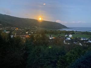 a view of a town with the sun setting on a hill at Bay View Porlock Bed & Breakfast in Porlock