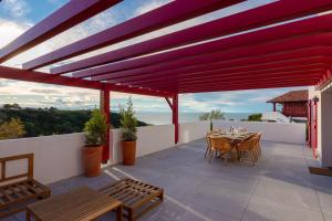 a patio with a table and chairs on a roof at SUNSET Keyweek Villa ocean view and private pool in Bidart