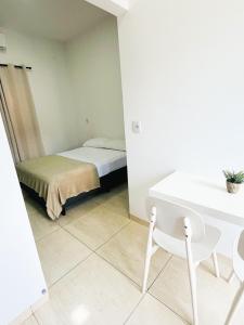 a small room with a bed and a table and chairs at Ap3 - Studio Confortável e Tranquilo in Guaíra