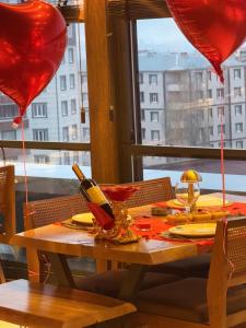 a table with red heart balloons and a window at New Konak Hotel in Bostaniçi