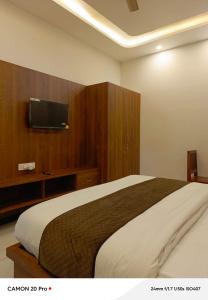 a bedroom with a large bed and a flat screen tv at Hotel Pushkar Town in Pushkar