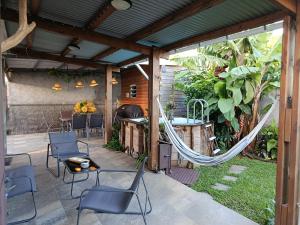 a patio with chairs and a hammock on it at Ti ' Jean 4 étoiles in Saint-Joseph