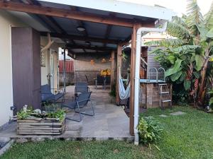 a covered patio with chairs and a table at Ti ' Jean 4 étoiles in Saint-Joseph