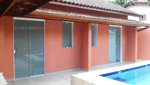 a house with orange walls and a swimming pool at Suite Recanto Cheiro Verde in Caraguatatuba +19 photos