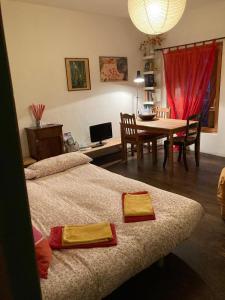 a room with two beds and a table and a dining room at Bed & Breakfast Villa Buzzati in Belluno