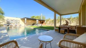 a patio with a pool and a table and chairs at Beautiful Asma Villa with pool in Marrakesh
