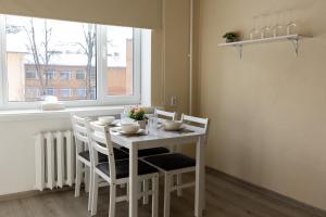 a white dining room table with chairs and a window at Aia apartment in Valga