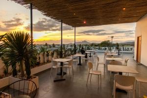 a restaurant with tables and chairs and a sunset at Santonita Hotel & Tours in Ninh Hải