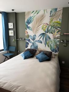 a bedroom with a large bed with blue pillows at Les Murmures du Rhône - Appartement Cosy et Lumineux in Andance +39 photos