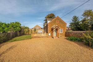 a brick house with a bench in a yard at No33 WOODLANDS BOUTIQUE COTTAGE in Heacham