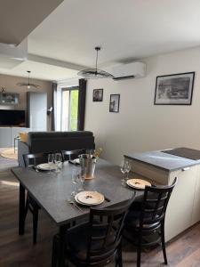 a table with plates and glasses on it in a kitchen at Les Murmures du Rhône - Appartement Cosy et Lumineux in Andance