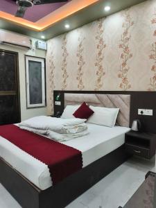 a bedroom with a large bed with a red blanket at Hotel Ramayanam palace in Ayodhya +43 photos