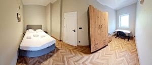 a bedroom with a bed and a large wooden door at Apartament Mickiewicza 3 in Września