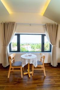 a dining room with a table and two chairs and a window at Villa Layna's home in An Bàn (2)