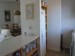 a kitchen with a refrigerator and a table with plates at King Fisher 6 in Mossel Bay