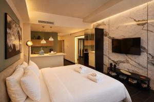 a hotel room with a bed and a television at Elite Ermou Suites in Athens