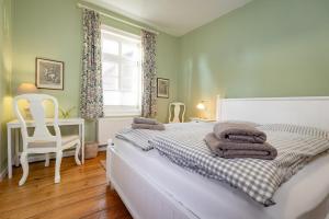 a bedroom with a bed and a chair and a window at Brauhaus am See in Gartow