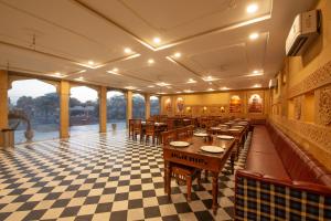 a restaurant with tables and chairs on a checkered floor at Heritage Juma Resort with swimming pool in Jaisalmer