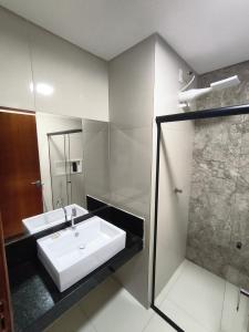 a bathroom with a sink and a shower at Hotel Colibri Viçosa - Próximo a UFV in Viçosa