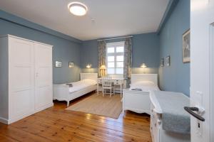 a bedroom with two beds and a table at Brauhaus am See in Gartow +16 photos
