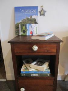 a wooden table with books and books at Gîte les Bois - 45 m2 in Orcival