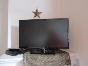 a large flat screen tv sitting on top of a table at Gîte les Bois - 45 m2 in Orcival +22 photos