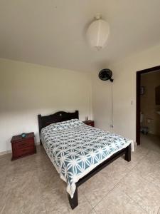 a bedroom with a bed and a dresser and a lamp at Lago Calima Hostel in Calima +5 photos