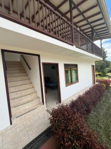 a house with a staircase leading to the entrance at Lago Calima Hostel in Calima